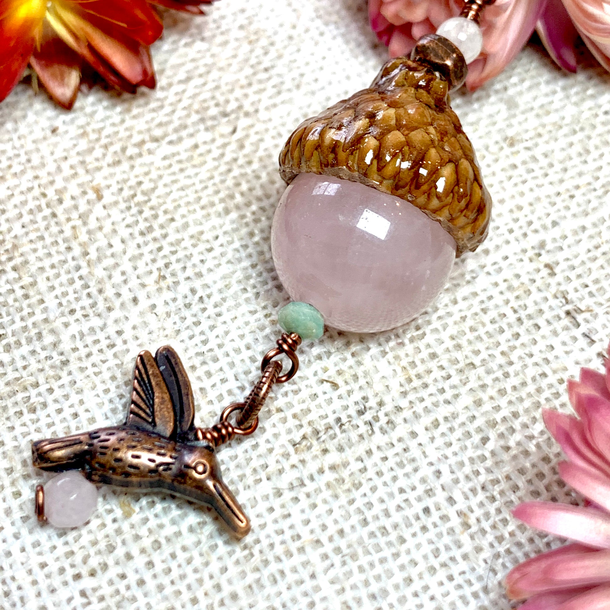 a close up of a necklace with a bird on it
